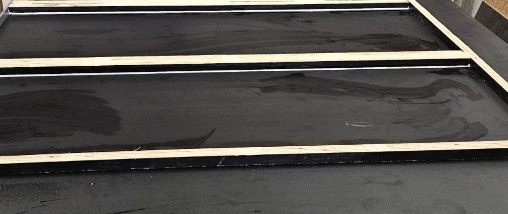 Drei schwarze gummierte Flächen mit hellen Rahmen, leicht verschmutzt.