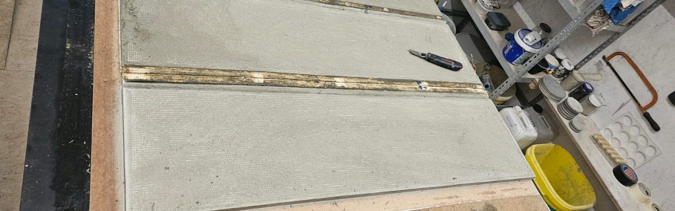 Betonfläche mit Werkzeugen und Materialien in einer Werkstatt.