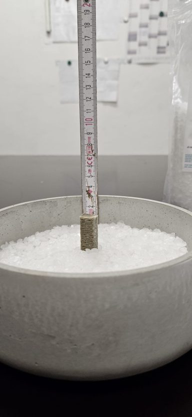 Weiße Kristalle in einer Schüssel mit einem Messstab in der Mitte.