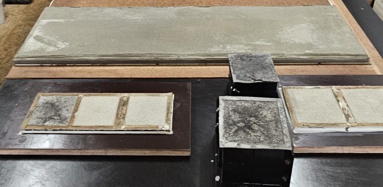 Drei Flächen mit unterschiedlichen Materialproben auf einem Tisch angeordnet.